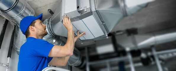 Engineer fitting spiral ductwork during the Wythenshawe warehouse install