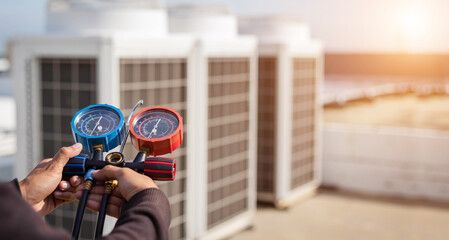 Engineer testing refrigerant pressure with manifold gauges